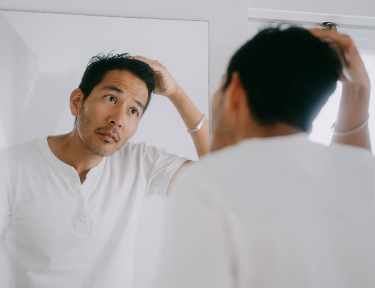Man looking in mirror, representing men's health and self-care
