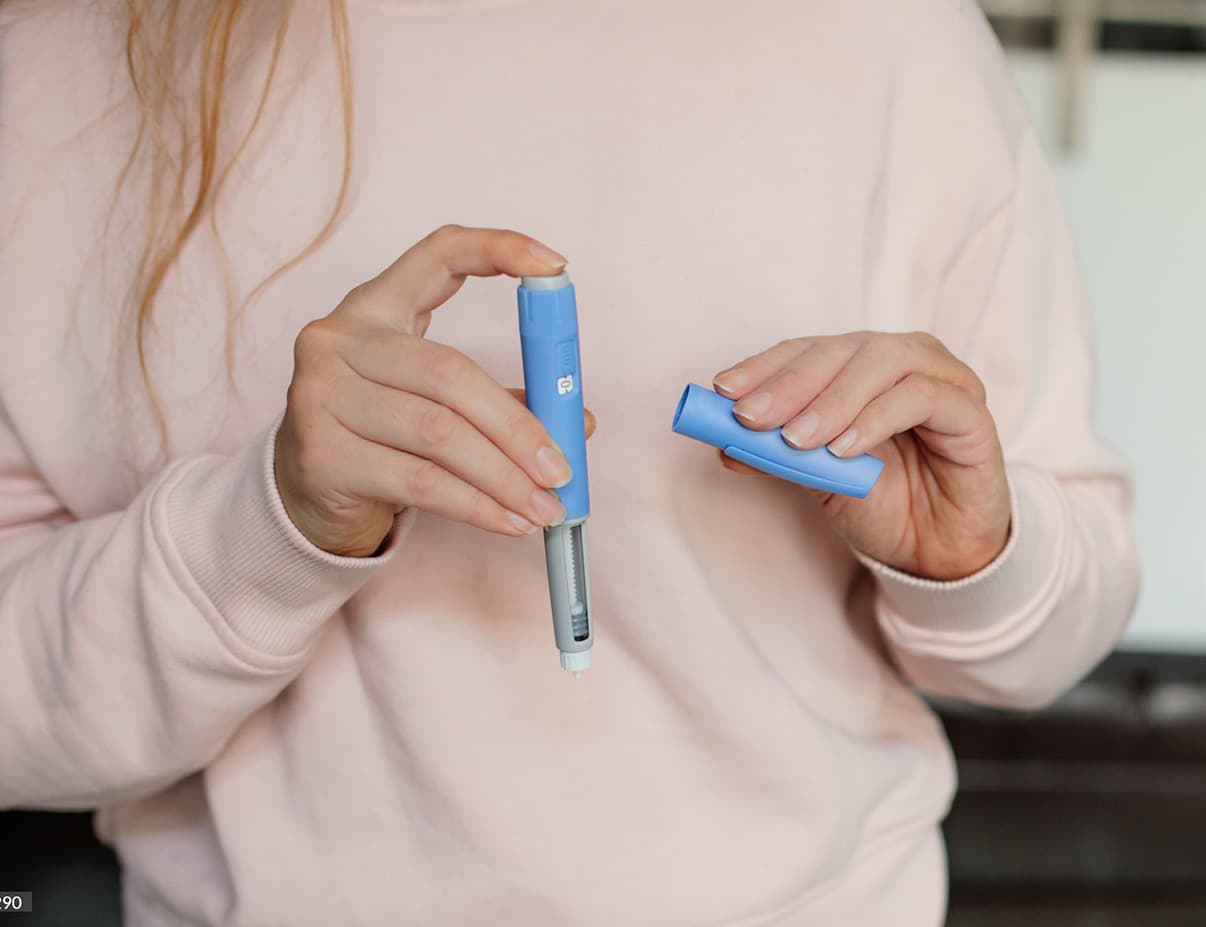 Woman holding a GLP-1 injection pen for weight loss treatment