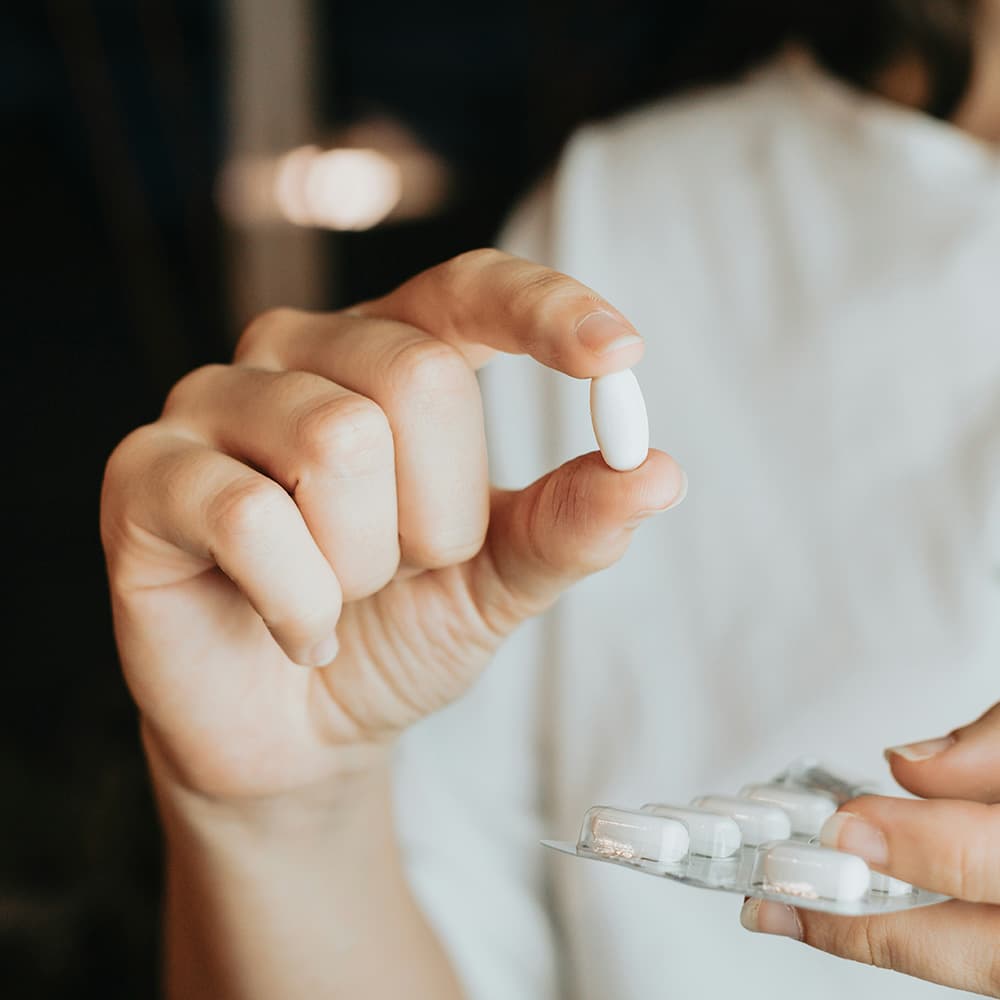 Woman holding a prescription medication capsule