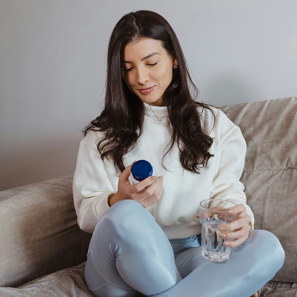 Woman relaxing on couch researching wellness products